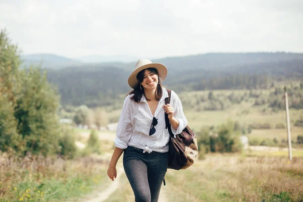 Glückliches Hipster-Mädchen mit Rucksack auf sonnigem Berg unterwegs — Stockfoto