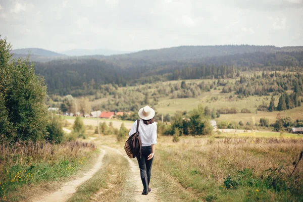 Hipster-Mädchen mit Rucksack unterwegs und zu Fuß auf sonnigem — Stockfoto