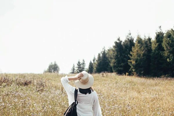 Hipster girl with backpack traveling in sunny mountains, walking — Stock Photo, Image