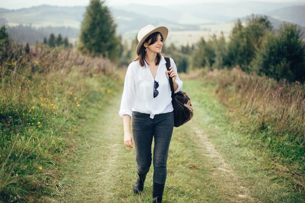 Chica hipster feliz con mochila viajando en la parte superior del monte soleado — Foto de Stock