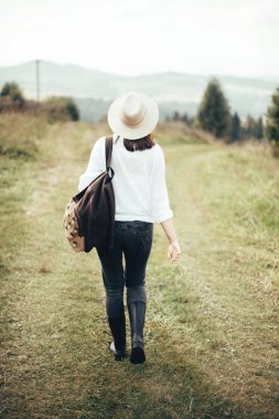 Sırt çantası ile Hipster kız seyahat ve güneşli üstüne yürüme