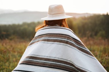 Şık boho kız atmosferik gün batımında güneşli ışıkta yürüyen i