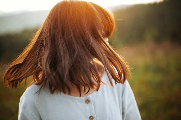 Stylish boho girl waving hair in sunny meadow at  atmospheric su — Stock Photo, Image