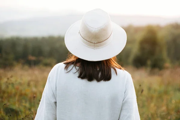 Stylisches Boho-Girl beim Spaziergang auf sonniger Wiese bei stimmungsvollem Sonnenuntergang — Stockfoto