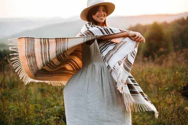 Happy hipster vrouw in poncho en hoed genieten van reizen in zelfs — Stockfoto