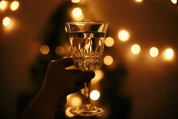 Altın noel t arka plan üzerinde el tutarak şampanya cam — Stok fotoğraf