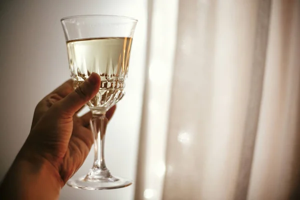 Hand innehav champagneglas på bakgrund av julbelysningen, — Stockfoto