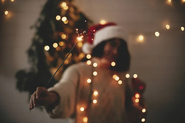 Big sparkler burning in hand of stylish hipster girl in santa ha — Stock Photo, Image