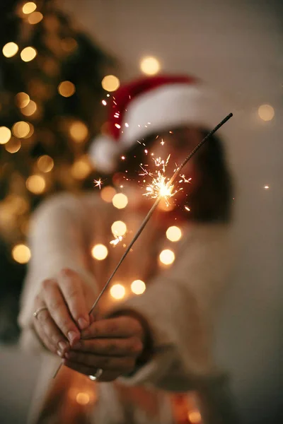 Happy New Year eve party atmosphere. Sparkler burning in hand of — Stock Photo, Image