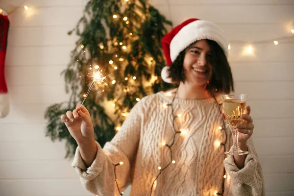 Santa şapka şık mutlu kız sparkler ve şampanya g tutan — Stok fotoğraf