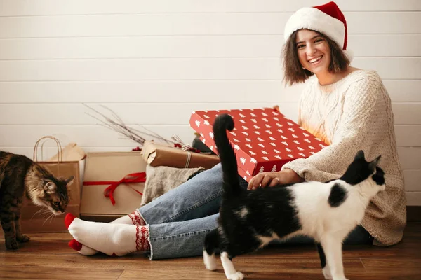 Stylowy szczęśliwy dziewczyna w Santa kapelusz i przytulny sweter otwarcie pakiety — Zdjęcie stockowe