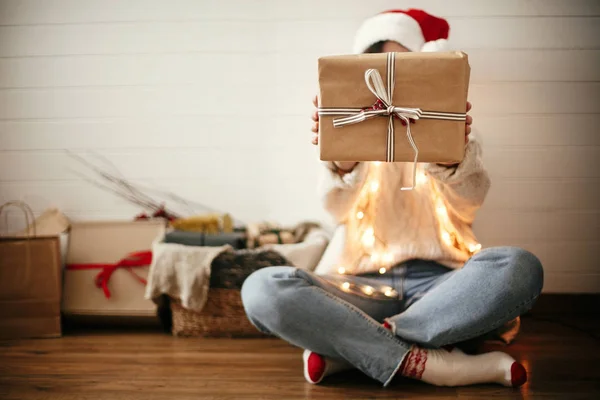 Простая рождественская подарочная коробка с лентой в руках стильного счастливого — стоковое фото