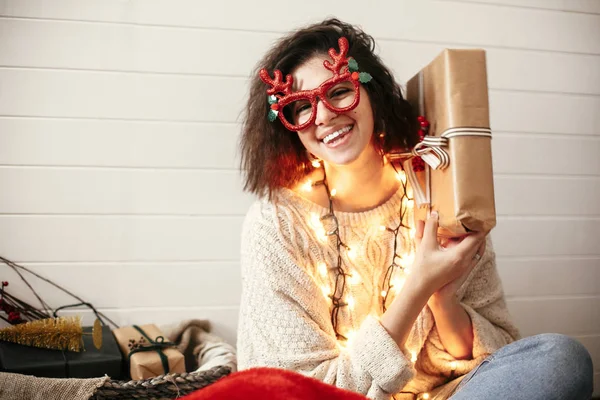 Stylish happy girl in festive glasses with reindeer antlers shak — Stock Photo, Image