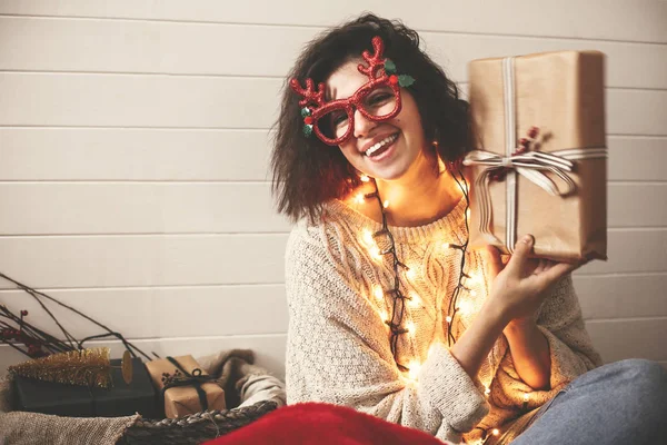 Stylish happy girl in festive glasses with reindeer antlers shak — Stock Photo, Image