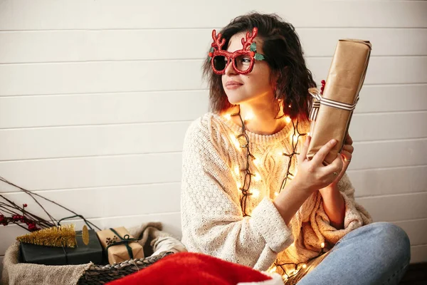 Stylish happy girl in festive glasses with reindeer antlers shak — Stock Photo, Image