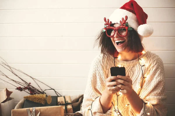 Stílusos boldog lány Santa kalap és ünnepi szemüveg a rénszarvas — Stock Fotó