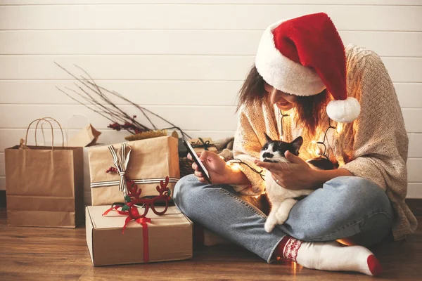 Stílusos boldog lány Santa hat nézi telefon képernyő vágott — Stock Fotó