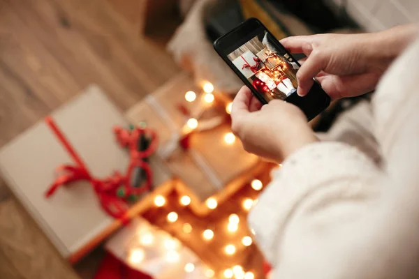 Hände halten Handy und fotografieren von Weihnachtsgeschenkboxen, sa — Stockfoto