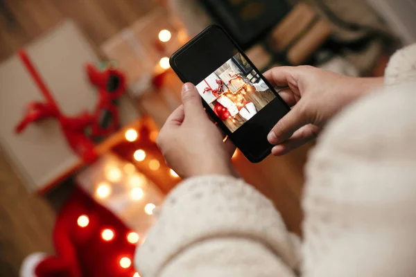 Ruce držící telefon a fotografovat vánoční dárkové krabice, SA — Stock fotografie