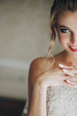 Rüzgara yakın yumuşak ışıkta poz veren inanılmaz makyajlı şık gelin