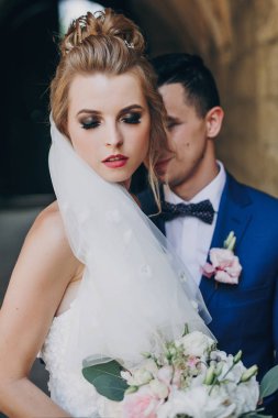 Şık gelin ve damat Avrupa şehir caddesinde nazikçe kucaklayan