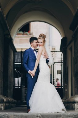 Şık gelin ve damat yavaşça güneşli Avrupa kenti st sarılma