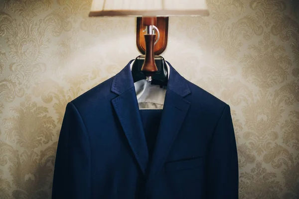 Stylový modrý oblek pro ženicha, který visí na lampě v hotelovém pokoji. Morni — Stock fotografie