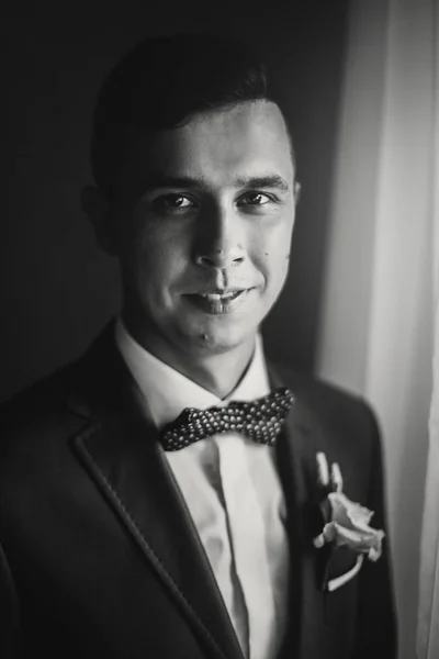 Elegante novio feliz en traje azul, con pajarita y boutonniere p — Foto de Stock