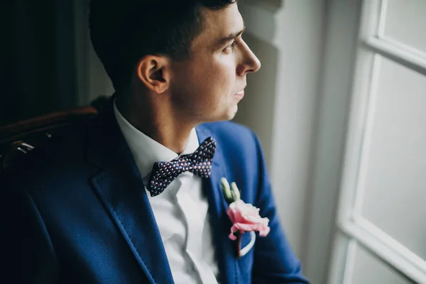 Elegante sposo in abito blu, con papillon e boutonniere con pi — Foto Stock