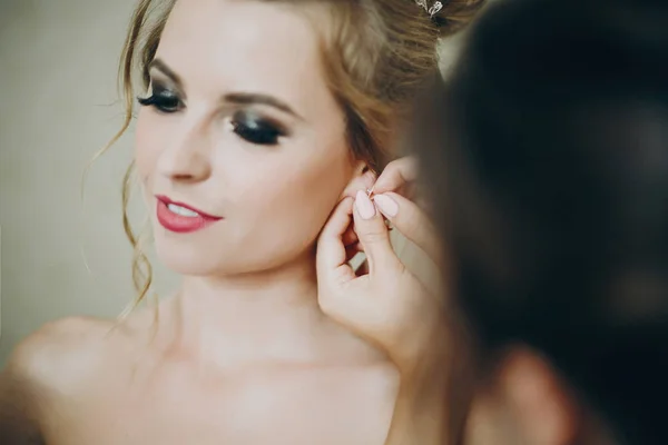 Stílusos koszorúslány segítve fel fülbevaló a menyasszony, felkészülnek — Stock Fotó
