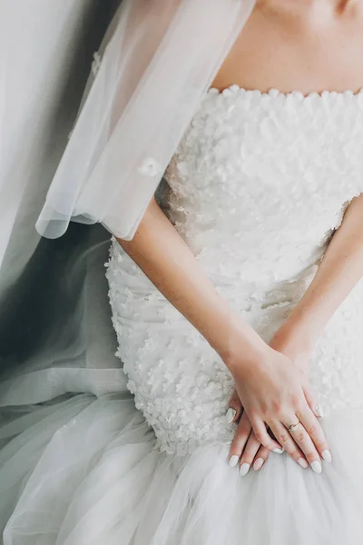 Elegante sposa che si tiene per mano con unghie rosa e bianche manicure o — Foto Stock