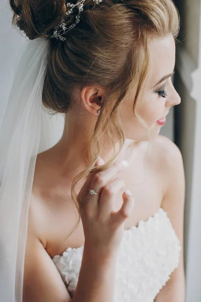 Stilvolle Braut posiert in weichem Licht in der Nähe von Fensterbalkon im Hotel — Stockfoto