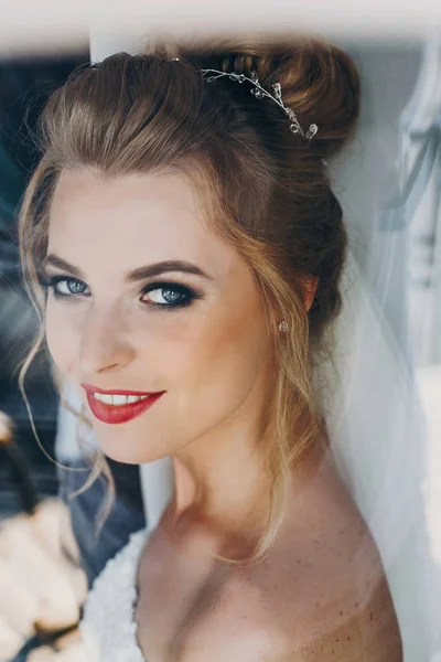 Noiva feliz elegante sorrindo e posando em luz suave perto da janela — Fotografia de Stock