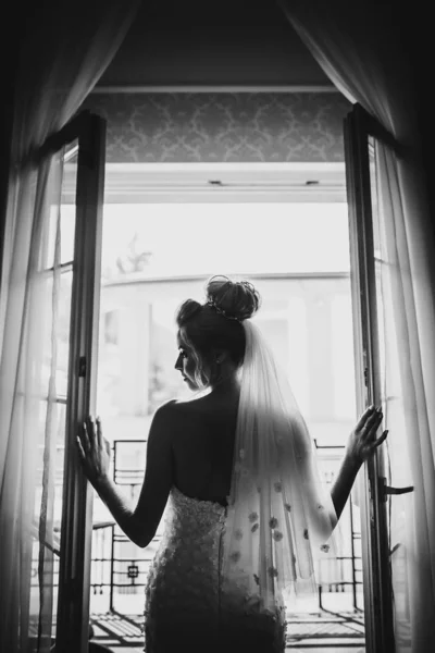 柔らかい光の中でスタイリッシュな花嫁の開口部窓バルコニーのシルエット — ストック写真