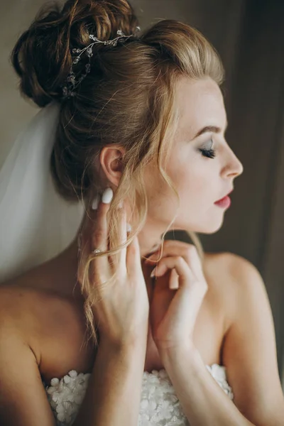 Noiva elegante posando em luz suave perto da janela no quarto de hotel. Vai. — Fotografia de Stock