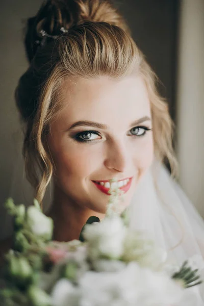 Noiva elegante segurando buquê de casamento moderno e posando em suave — Fotografia de Stock