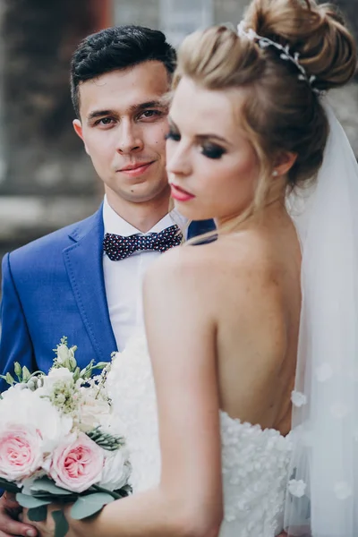Stylová nevěsta a ženich se jemně pletou ve slunném evropském městě — Stock fotografie