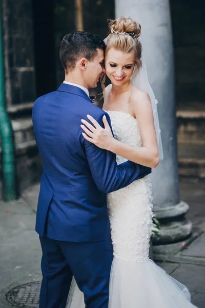Stilvolle Braut und Bräutigam sanft umarmen in sonnigen europäischen Stadt st — Stockfoto