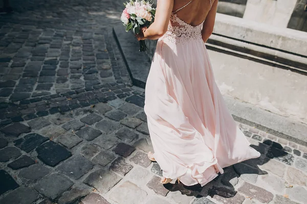 Dama de honra elegante em vestido rosa andando na rua da cidade europeia — Fotografia de Stock