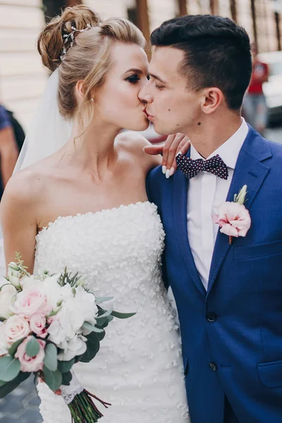 Elegante novia feliz y novio besándose en la vieja ciudad europea stree — Foto de Stock