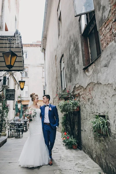Elegante novia feliz y novio caminando en la vieja calle de la ciudad. Gorgeo. —  Fotos de Stock