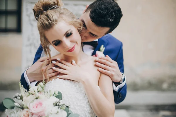 Stylish bride and groom kissing sensually in sunny european city — Stock Photo, Image