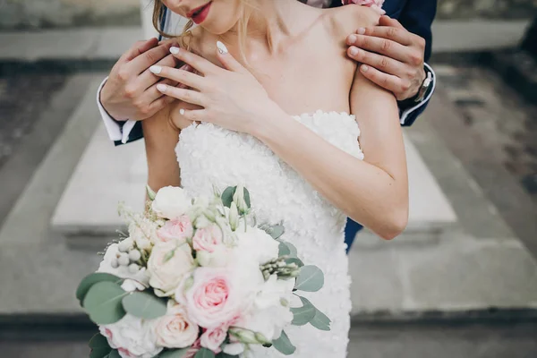 Elegante noivo beijando sensualmente sua noiva feliz na Europa ensolarada — Fotografia de Stock