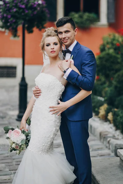 Mariée élégante et marié posant dans la rue ensoleillée de la ville européenne. Vas-y. — Photo