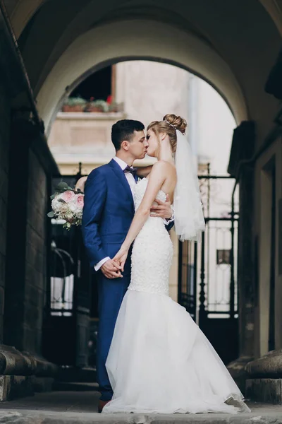 Stilvolle Braut und Bräutigam sanft küssen in sonnigen europäischen Stadt st — Stockfoto