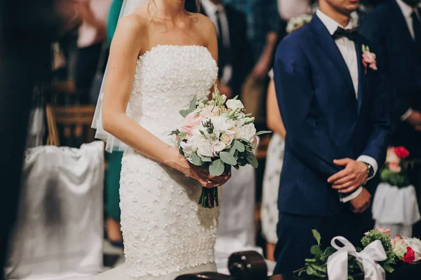 Casal elegante em pé na igreja para o matrimônio sagrado. Seja — Fotografia de Stock