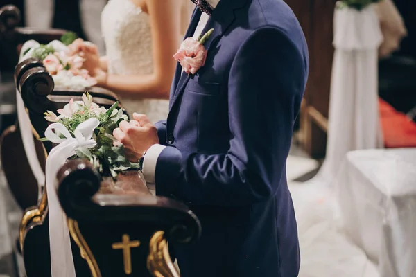 Snygg bröllopspar stående i kyrkan för heliga äktenskap. Bve — Stockfoto