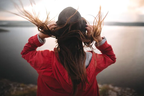 Мандрівник дівчина в капелюсі і з вітряним волоссям, що стоїть на вершині каменю — стокове фото