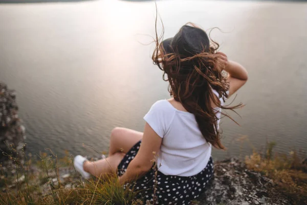 Reisenden Hipster-Mädchen mit Hut und windigen Haaren sitzt auf dem Dach — Stockfoto