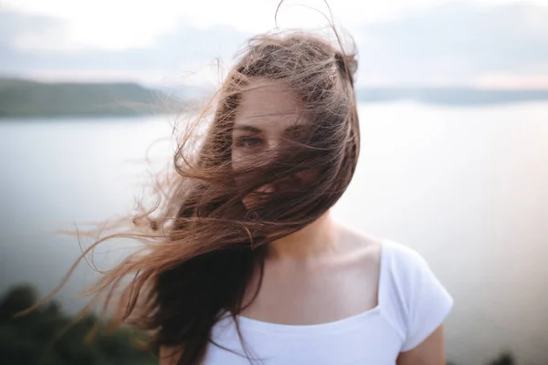 Портрет дівчини-гіпстера з вітряним волоссям, що стоїть на вершині каменю — стокове фото